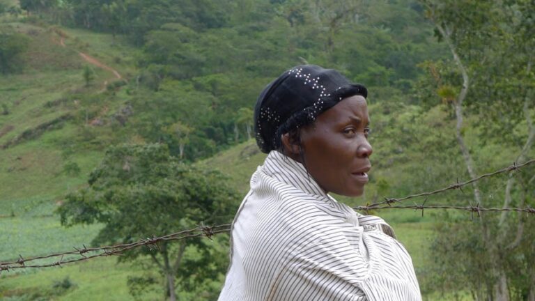 Productrice de café haïtienne devant les parcelles de sa ferme familiale