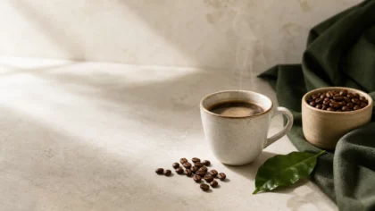 Tasse de café préparé près de grains torréfiés sur une surface neutre